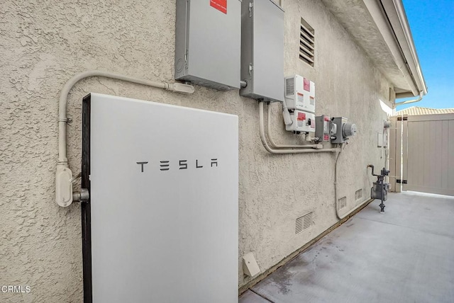 885 Oakland Hills Dr, Banning, CA 92220 - exterior view of a power storage unit, stucco siding, gas meter, and related energy utilities