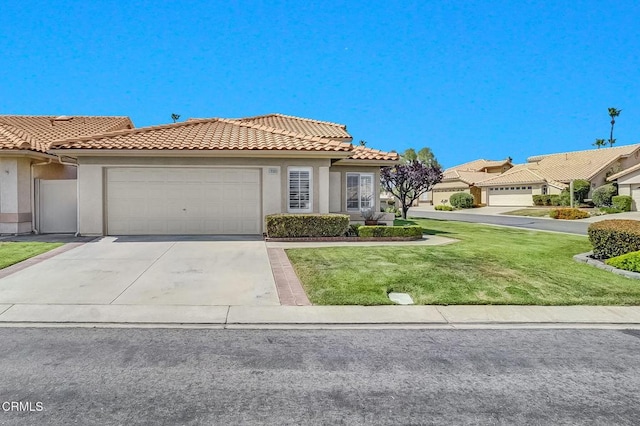 885 Oakland Hills Dr, Banning, CA 92220 - view of front facade featuring stucco siding, a tile roof, an attached garage, concrete driveway, and a front yard