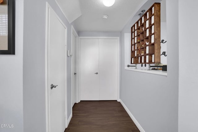885 Oakland Hills Dr, Banning, CA 92220 - corridor featuring dark wood-style floors, baseboards, and a textured ceiling