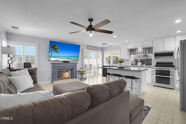 885 Oakland Hills Dr, Banning, CA 92220 - living room featuring ceiling fan, a glass covered fireplace, recessed lighting, plenty of natural light, and baseboards