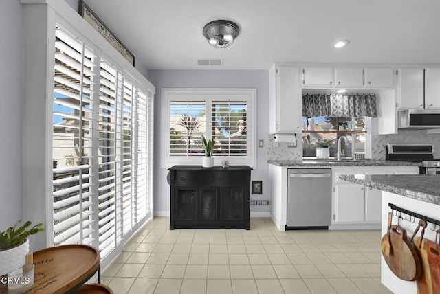 885 Oakland Hills Dr, Banning, CA 92220 - kitchen featuring stainless steel appliances, tasteful backsplash, white cabinetry, light tile patterned floors, and recessed lighting