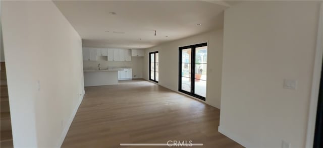33710 Santiago Rd, Acton, CA 93510 - unfurnished living room with light wood-style floors, baseboards, and a sink