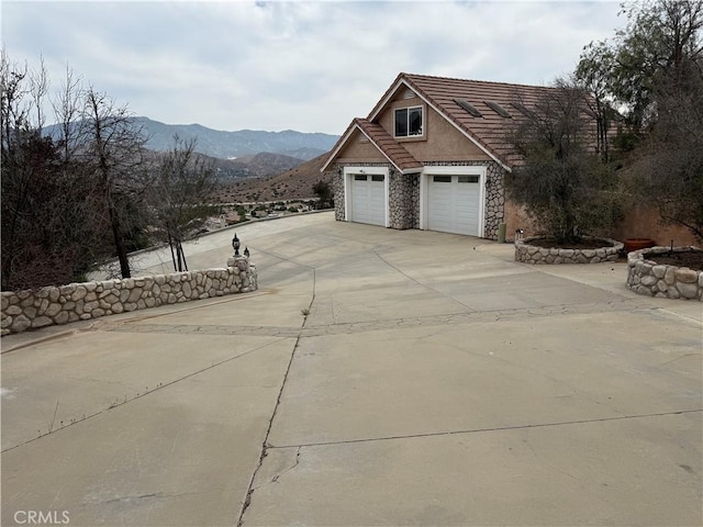 33710 Santiago Rd, Acton, CA 93510 - view of side of property with a tile roof, stone siding, driveway, a mountain view, and stucco siding