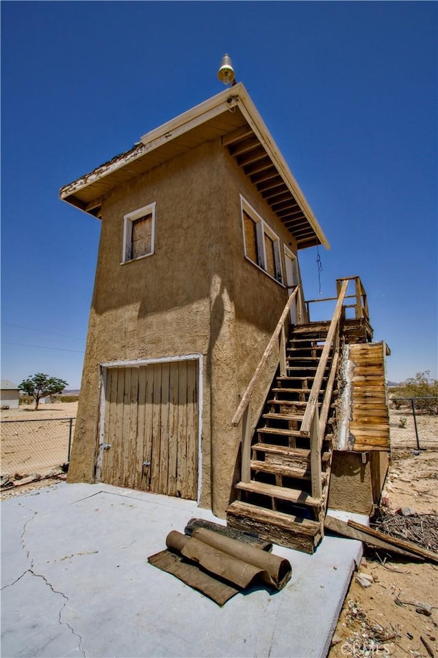 62853 Desert Trail Dr, Joshua Tree, CA 92252 - view of side of home featuring stucco siding and stairway