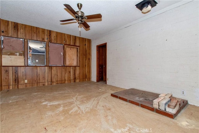 62853 Desert Trail Dr, Joshua Tree, CA 92252 - spare room with a ceiling fan, wooden walls, and brick wall