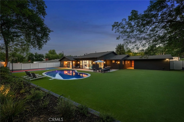 20215 Lorenzana Dr, Woodland Hills, CA 91364 - back of house at dusk with a patio and board and batten siding