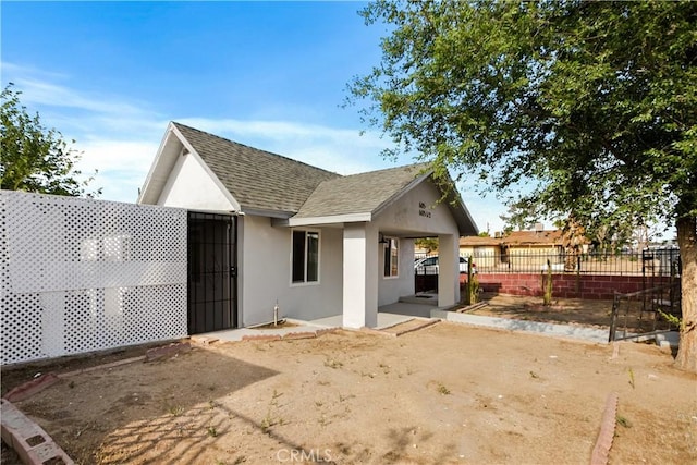 605 E Fredricks St, Barstow, CA 92311 - rear view of house featuring stucco siding, roof with shingles, and a patio