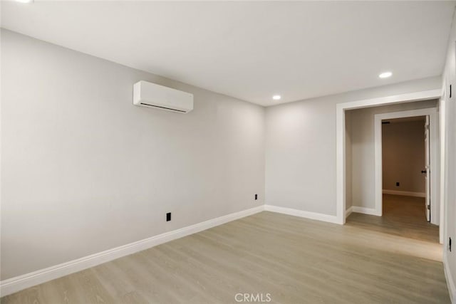 605 E Fredricks St, Barstow, CA 92311 - spare room with a wall unit AC, light wood-style floors, recessed lighting, and baseboards