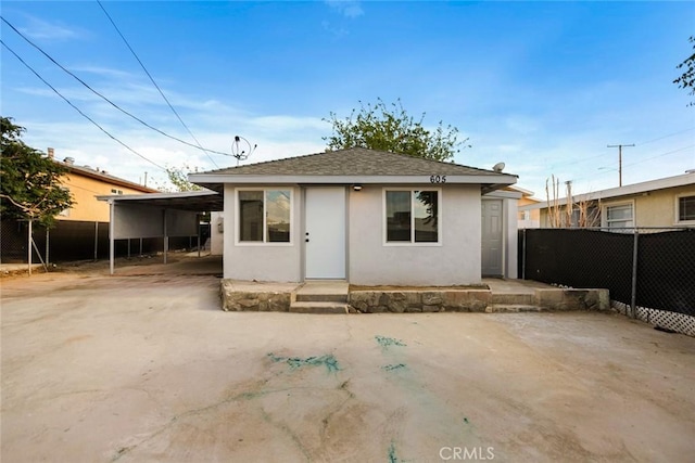 605 E Fredricks St, Barstow, CA 92311 - view of front of house with stucco siding, a shingled roof, an attached carport, and driveway