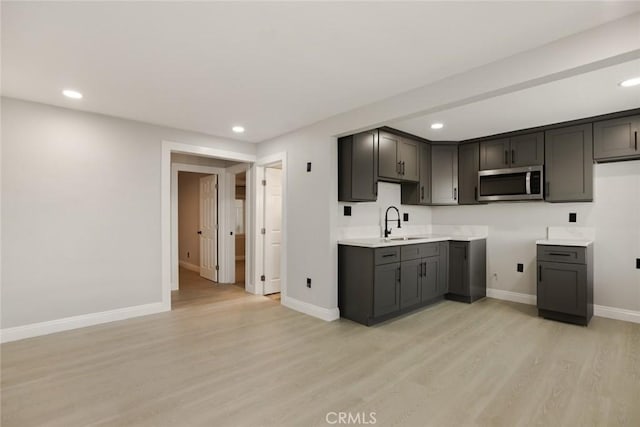 605 E Fredricks St, Barstow, CA 92311 - kitchen with stainless steel microwave, light wood finished floors, recessed lighting, a sink, and baseboards
