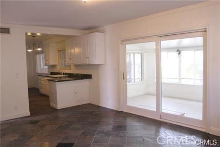 1679 N 2nd Ave, Upland, CA 91784 - kitchen featuring dark countertops, white cabinets, a chandelier, and a peninsula