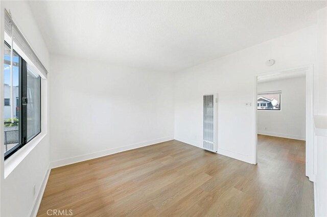 1242 Cedar Ave, Long Beach, CA 90813 - empty room with a heating unit, wood finished floors, and baseboards