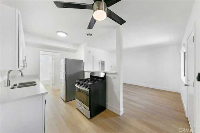 1242 Cedar Ave, Long Beach, CA 90813 - kitchen featuring stainless steel gas range oven, freestanding refrigerator, a sink, and light wood-type flooring