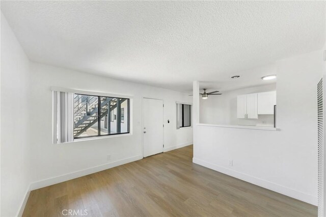 1242 Cedar Ave, Long Beach, CA 90813 - unfurnished living room with wood finished floors, a textured ceiling, baseboards, and a ceiling fan