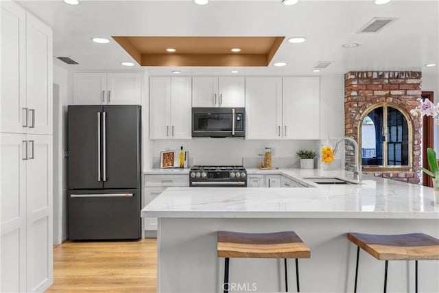5144 Meadow Wood Ave, Lakewood, CA 90712 - kitchen featuring freestanding refrigerator, range with gas stovetop, a peninsula, white cabinets, and recessed lighting