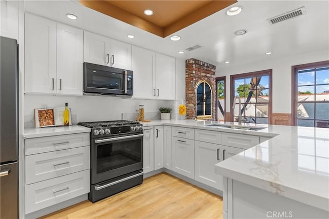 5144 Meadow Wood Ave, Lakewood, CA 90712 - kitchen featuring appliances with stainless steel finishes, a peninsula, recessed lighting, white cabinetry, and light stone counters