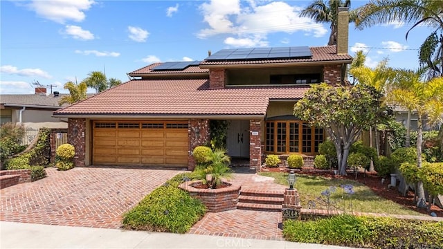 5144 Meadow Wood Ave, Lakewood, CA 90712 - view of front of property featuring a tile roof, an attached garage, roof mounted solar panels, and decorative driveway