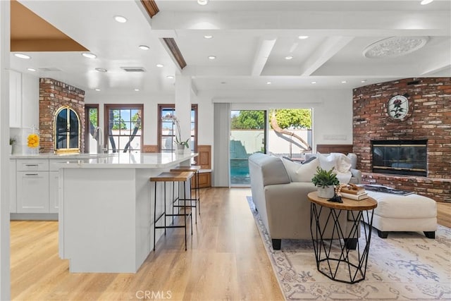 5144 Meadow Wood Ave, Lakewood, CA 90712 - living area featuring a brick fireplace, light wood finished floors, beam ceiling, recessed lighting, and coffered ceiling