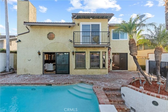 5144 Meadow Wood Ave, Lakewood, CA 90712 - rear view of house featuring a balcony, stucco siding, an outdoor pool, and a patio