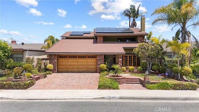 5144 Meadow Wood Ave, Lakewood, CA 90712 - view of front of property with a tiled roof, roof mounted solar panels, decorative driveway, and a chimney