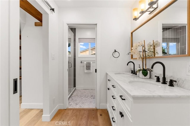 5144 Meadow Wood Ave, Lakewood, CA 90712 - bathroom featuring wood finished floors, double vanity, and a shower with shower door