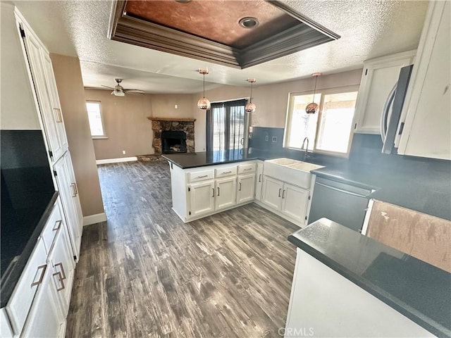 15395 Apache Rd, Apple Valley, CA 92307 - kitchen featuring a sink, a raised ceiling, a stone fireplace, a ceiling fan, and a textured ceiling