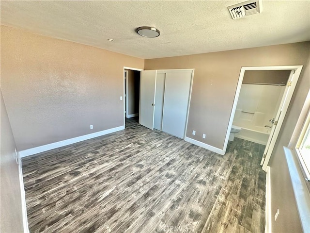 15395 Apache Rd, Apple Valley, CA 92307 - unfurnished bedroom with wood finished floors, baseboards, a textured ceiling, a closet, and ensuite bathroom