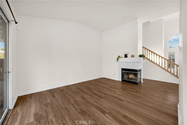 27472 Swallow Ct, Temecula, CA 92591 - unfurnished living room featuring wood finished floors, a fireplace, stairway, and lofted ceiling