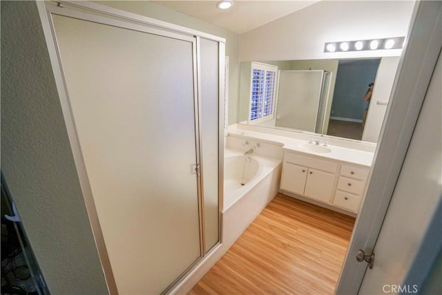 14194 De Sota Dr, Victorville, CA 92392 - full bath featuring a stall shower, wood finished floors, a bath, vanity, and recessed lighting