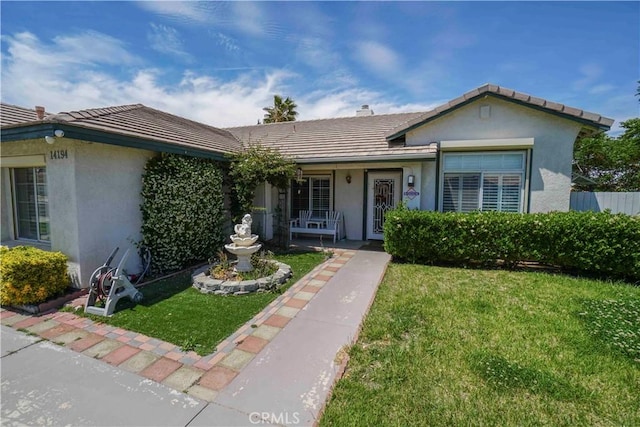 14194 De Sota Dr, Victorville, CA 92392 - view of front of property with stucco siding, a front yard, a tiled roof, and covered porch