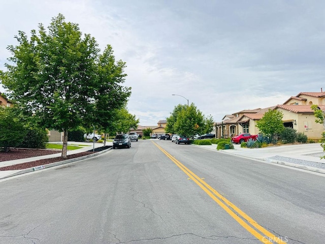 24802 Sandy Trail Pl, Menifee, CA 92584 - view of asphalt road featuring sidewalks, curbs, street lights, and a residential view