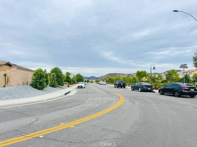 24802 Sandy Trail Pl, Menifee, CA 92584 - view of asphalt road featuring street lighting, sidewalks, and a mountain view