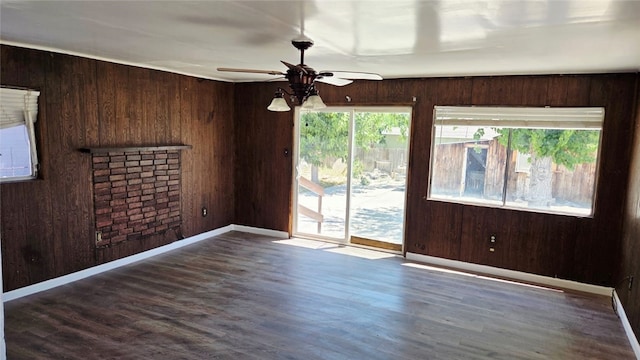 322 S 8th St, Taft, CA 93268 - spare room with healthy amount of natural light, a ceiling fan, wood walls, wood finished floors, and a fireplace