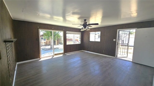 322 S 8th St, Taft, CA 93268 - empty room featuring dark wood-style flooring, ceiling fan, plenty of natural light, and wood walls