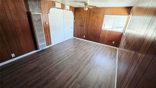322 S 8th St, Taft, CA 93268 - empty room featuring a heating unit, a ceiling fan, wood finished floors, and wooden walls