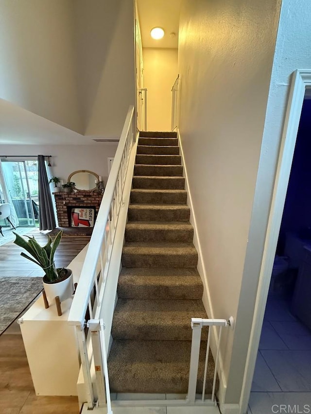 25675 Via Del Rey, San Juan Capistrano, CA 92675 - staircase with a fireplace, tile patterned floors, and a high ceiling