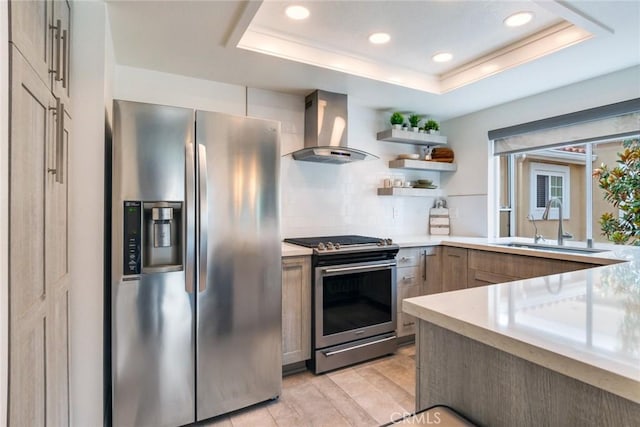 2444 Paseo Circulo, Tustin, CA 92782 - kitchen featuring appliances with stainless steel finishes, wall chimney range hood, light countertops, a tray ceiling, and a sink