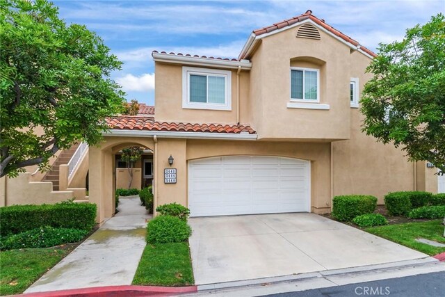 2444 Paseo Circulo, Tustin, CA 92782 - mediterranean / spanish home featuring a tiled roof, stucco siding, an attached garage, and concrete driveway