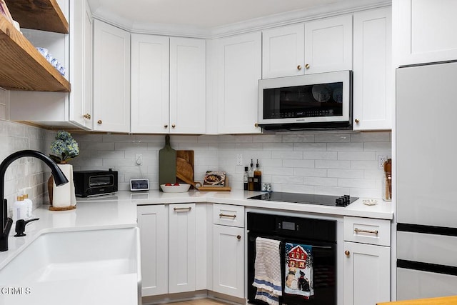 4210 Via Arbolada Unit 308, Los Angeles, CA 90042 - kitchen featuring black appliances, a sink, light countertops, tasteful backsplash, and white cabinets