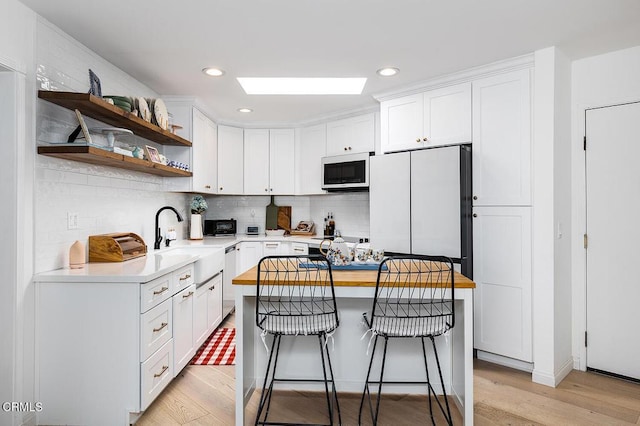 4210 Via Arbolada Unit 308, Los Angeles, CA 90042 - kitchen featuring white microwave, a sink, light wood-style floors, light countertops, and recessed lighting