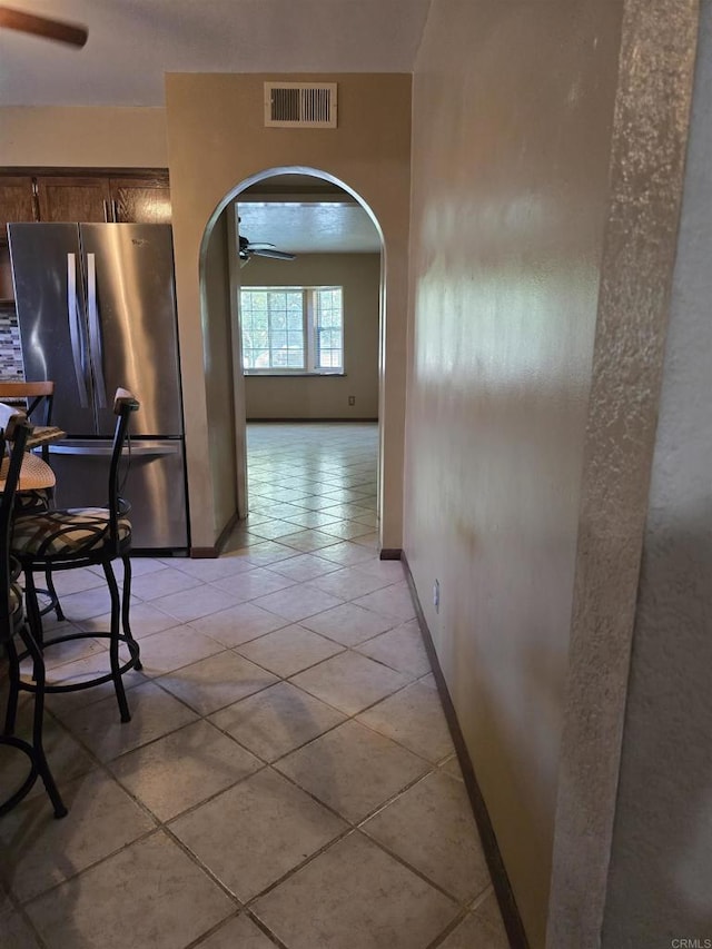 704 S H St, Imperial, CA 92251 - hallway featuring arched walkways, baseboards, and light tile patterned flooring