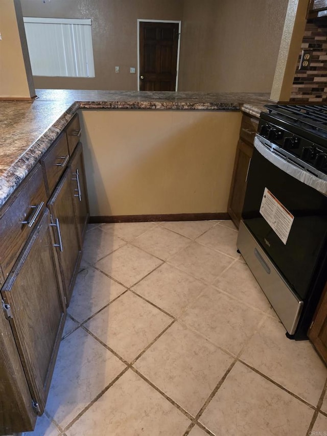 704 S H St, Imperial, CA 92251 - kitchen featuring stainless steel range with gas stovetop, a peninsula, and light tile patterned floors