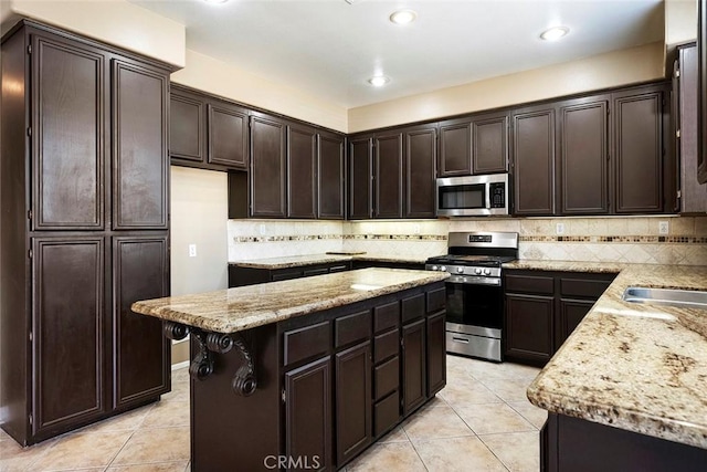 39766 Pinedale Way, Murrieta, CA 92562 - kitchen with appliances with stainless steel finishes, dark brown cabinets, light tile patterned floors, a kitchen island, and recessed lighting
