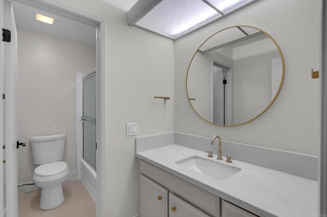 22 Seaview Dr S, Rolling Hills Estates, CA 90274 - full bathroom featuring vanity, toilet, tile patterned flooring, combined bath / shower with glass door, and baseboards