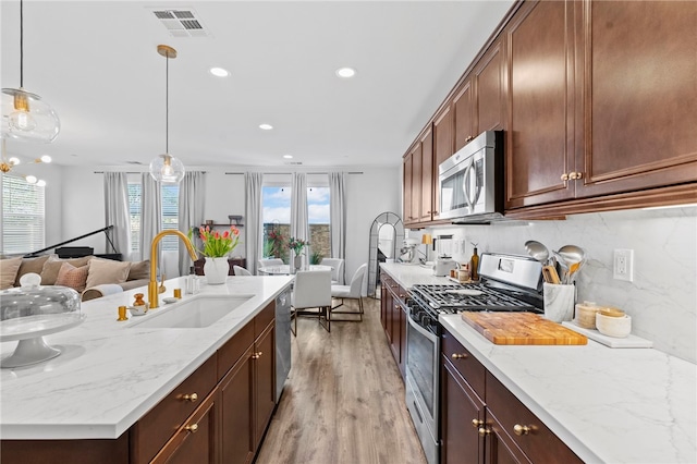 2851 Menorca Cir, Corona, CA 92881 - kitchen featuring appliances with stainless steel finishes, a sink, open floor plan, light wood finished floors, and recessed lighting