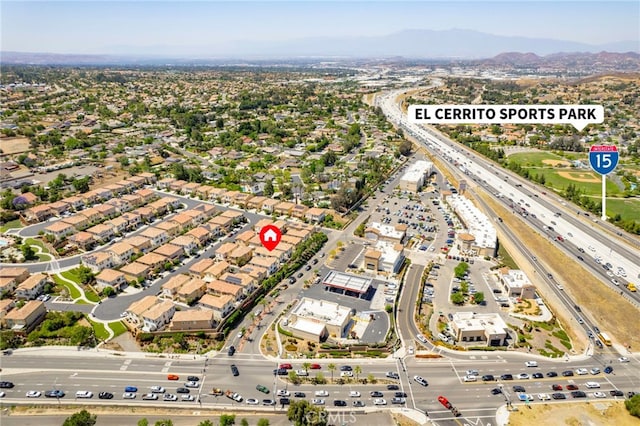 2851 Menorca Cir, Corona, CA 92881 - aerial overview of property's location featuring a major roadway, a mountain backdrop, and nearby suburban area