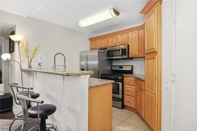 4401 Sepulveda Blvd Unit 112, Sherman Oaks, CA 91403 - kitchen featuring stainless steel appliances, a kitchen breakfast bar, light stone countertops, a sink, and light tile patterned floors