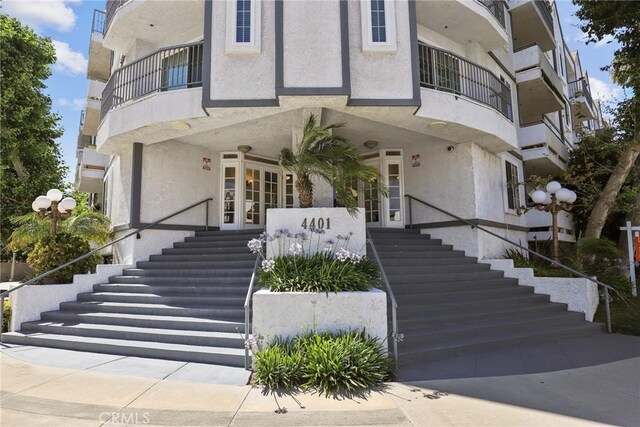 4401 Sepulveda Blvd Unit 112, Sherman Oaks, CA 91403 - view of front of home featuring stucco siding, a balcony, and stairway