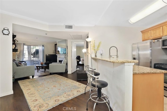 4401 Sepulveda Blvd Unit 112, Sherman Oaks, CA 91403 - kitchen with stainless steel appliances, a kitchen bar, light brown cabinetry, light stone countertops, and crown molding