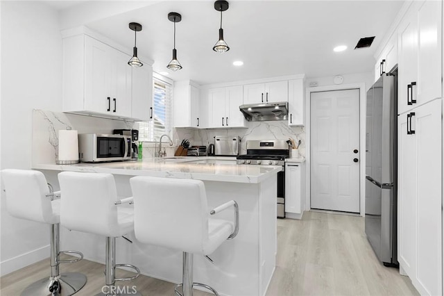 19378 Fadden St, Rowland Heights, CA 91748 - kitchen with stainless steel appliances, under cabinet range hood, a peninsula, a sink, and light wood-type flooring
